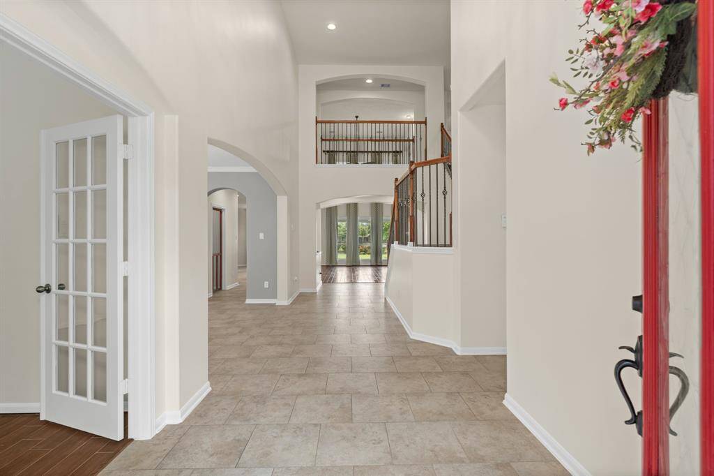 First impressions matter! Imagine being greeted by an abundance of natural light and a sense of spaciousness in this stunning entryway with its soaring ceilings.