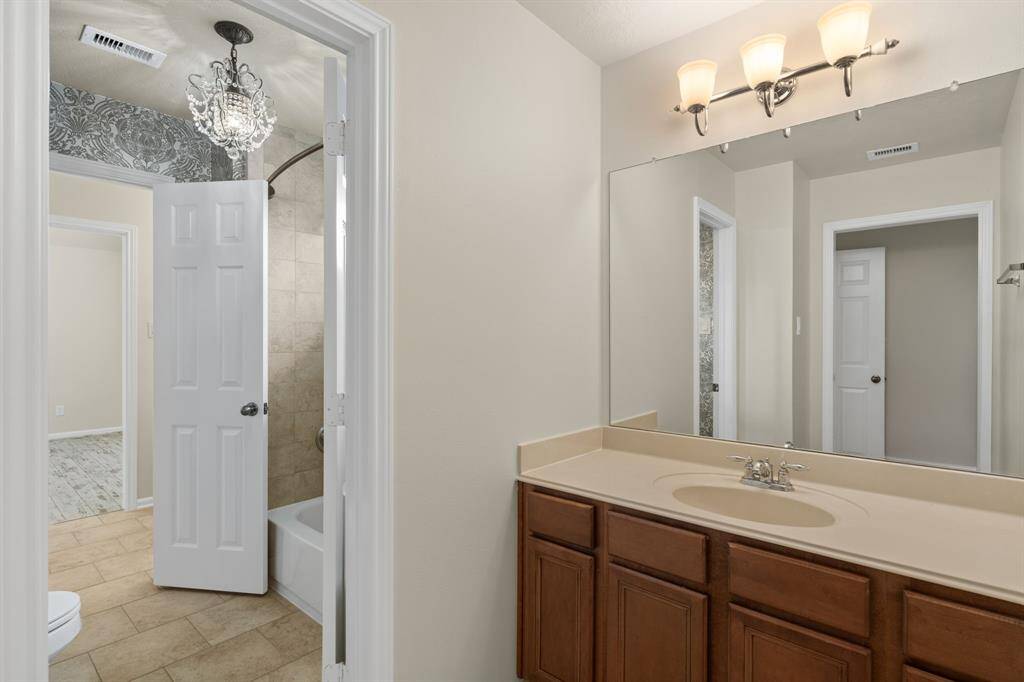 This practical full bathroom is designed with two access doors, connecting seamlessly to two separate second-floor bedrooms, offering convenience for family or guests.