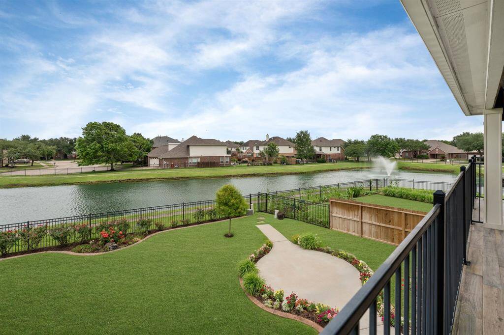 This inviting second-floor balcony offers a comfortable outdoor space with refreshing large fans and picturesque panoramas of the garden and the tranquil lake.