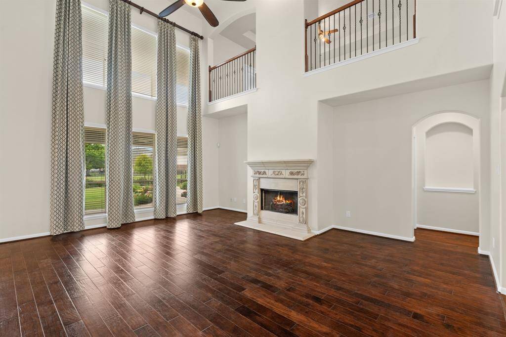 Experience the bright and airy ambiance of this living room, featuring soaring high ceilings, windows galore showcasing beautiful lake views, and perfectly positioned for easy flow to the kitchen, entryway, and your private primary retreat.