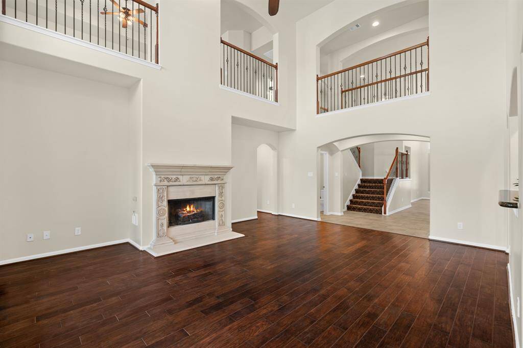 Experience the bright and airy ambiance of this living room, featuring soaring high ceilings, windows galore showcasing beautiful lake views, and perfectly positioned for easy flow to the kitchen, entryway, and your private primary retreat.