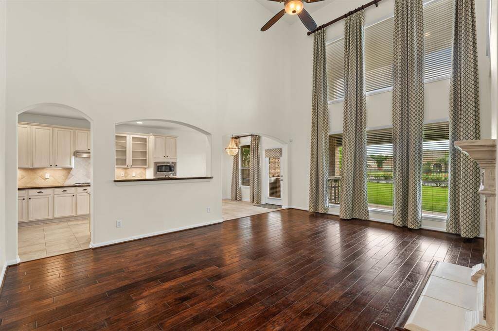 Experience the bright and airy ambiance of this living room, featuring soaring high ceilings, windows galore showcasing beautiful lake views, and perfectly positioned for easy flow to the kitchen, entryway, and your private primary retreat.