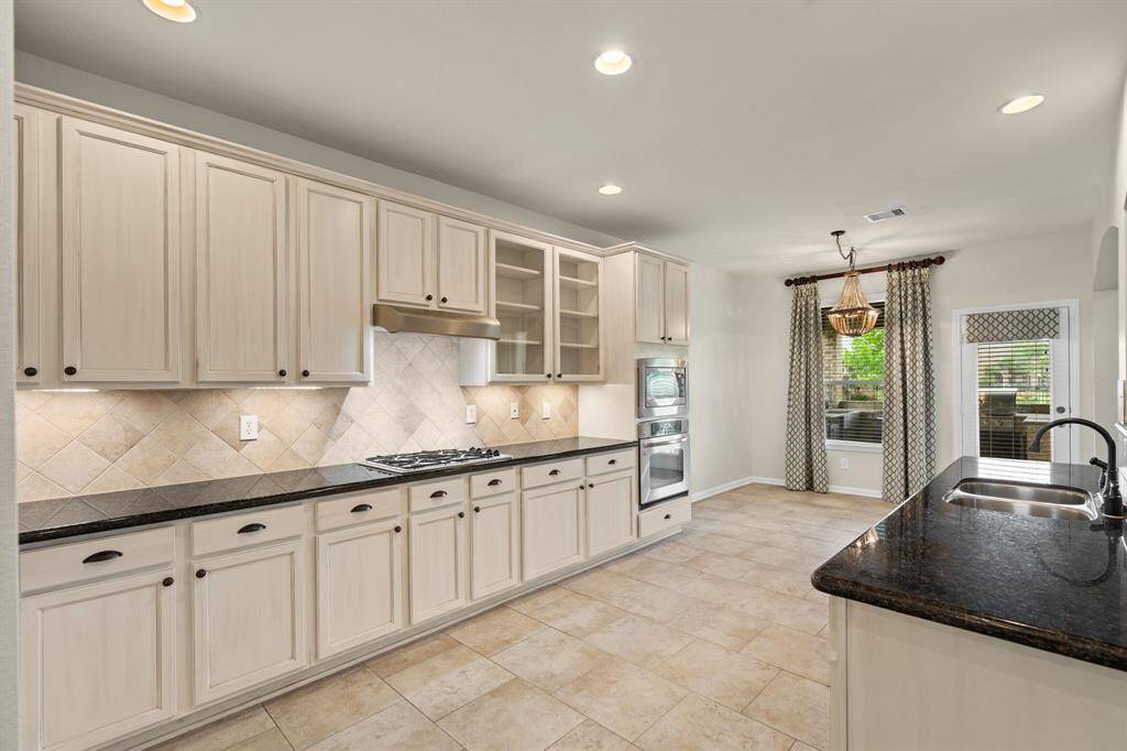 This spacious kitchen boasts an informal dining area with stunning lake views, seamless access to the living area and formal dining room, plus a conveniently tucked-away utility room.