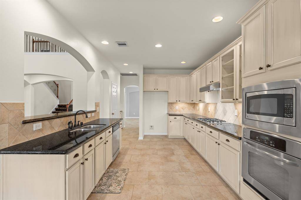 This spacious kitchen boasts an informal dining area with stunning lake views, seamless access to the living area and formal dining room, plus a conveniently tucked-away utility room.