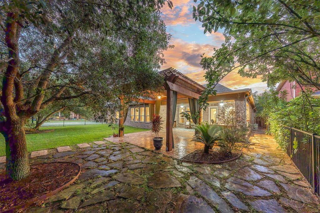 Enjoy tranquil lakefront living in this beautifully landscaped backyard, complete with a wrought iron fence and mature shade trees. The expansive stamped concrete patio with pergola, ceiling fan, and outdoor kitchen creates the ideal setting for entertaining or relaxing in your private sanctuary.