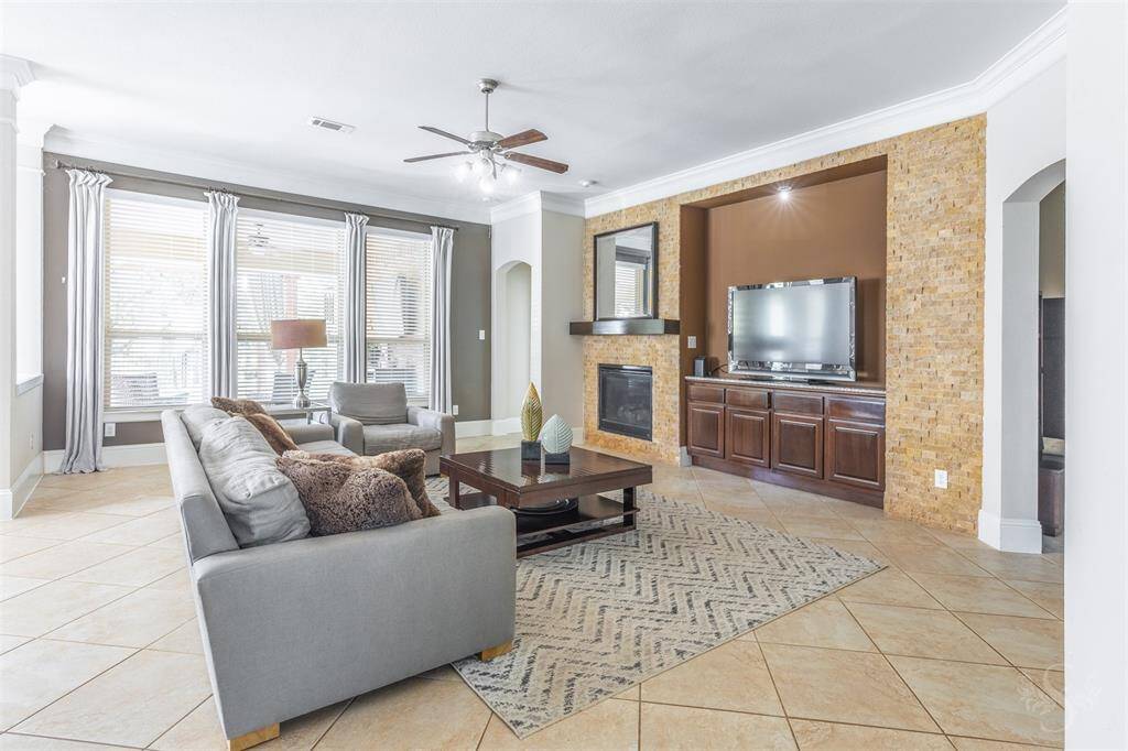 This stunning family room exudes warmth with a stone-accented fireplace, custom built-ins, and expansive windows framing serene waterfront views. It's the perfect space to gather, relax, and soak in the beauty of your backyard haven.