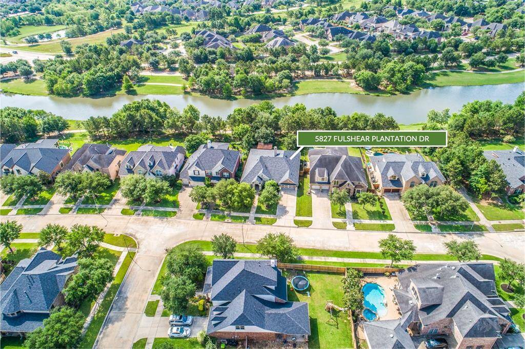 Nestled on a peaceful lakefront lot, this David Weekly home offers picturesque views and direct access to scenic walking trails in Cross Creek Ranch. The aerial perspective showcases the home’s prime location near the water and beautifully landscaped neighborhood.