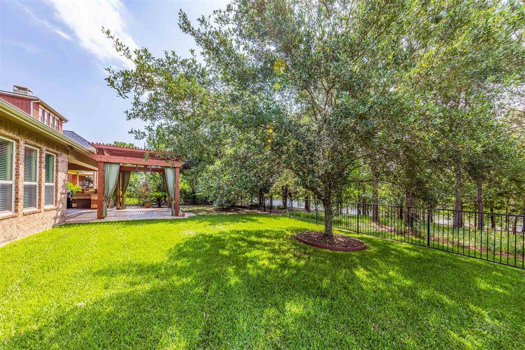 With a lush lawn, mature trees, and a direct view of the lake trail beyond, this backyard feels like your own private park. The elegant pergola and beautifully landscaped setting make this outdoor space both inviting and impressive.