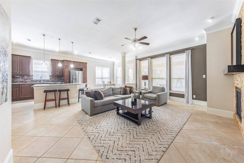 Natural light pours into the open-concept family room, where the windows overlook the peaceful water view beyond. This airy layout blends beauty and functionality, ideal for both everyday living and entertaining.