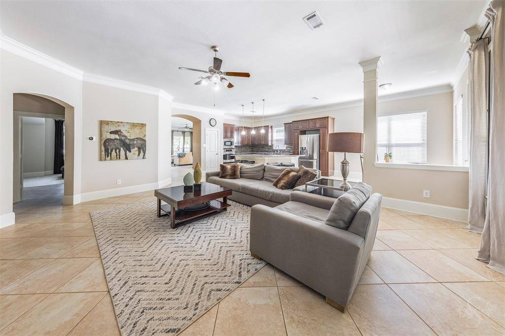 The expansive family room flows effortlessly into the kitchen, with high ceilings, crown molding, and soft arches creating architectural interest. Generous space makes it easy to gather and entertain!