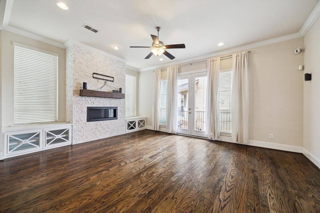 Alternate view of living room that leads out to covered outdoor balcony.