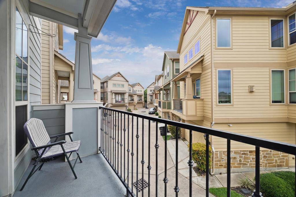 Charming balcony view of a modern townhouse community, featuring well-maintained exteriors and a cozy seating area. Ideal for relaxing and enjoying the neighborhood ambiance.