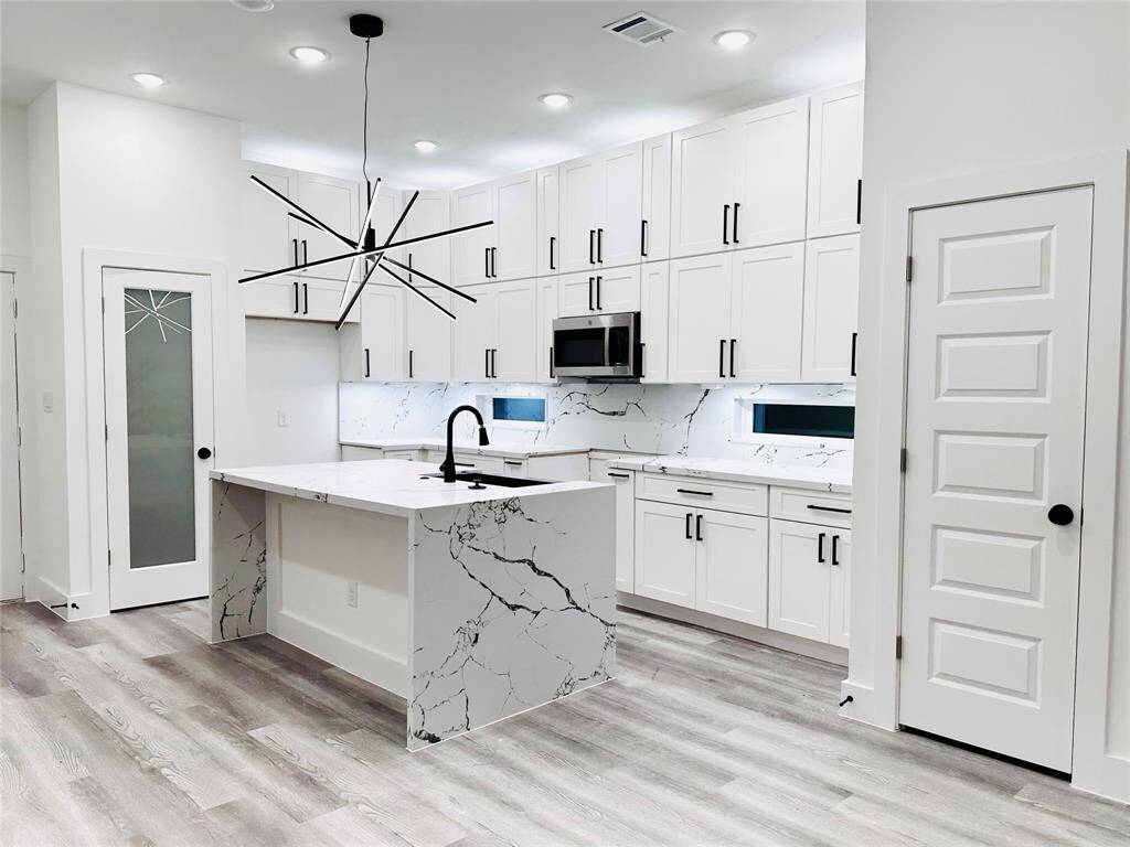 Will have similar finishes. Kitchen features 3cm full quartz backsplash, matte black farm sink, 2x pantrys, 2x spice racks next to the gas range, hidden electrical plugs, double stacked solid wood wall cabinets w/ soft close draws/doors, waterfall island, oversized LED chandelier, and more!