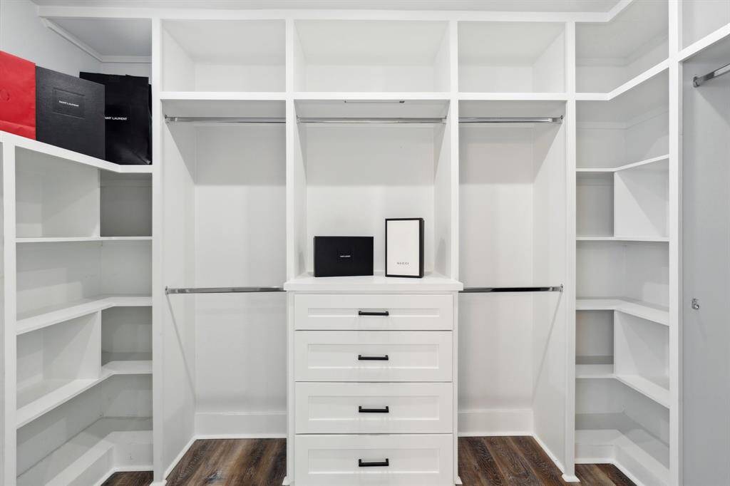 Walk-in closet #1 with built in dresser and shelving.