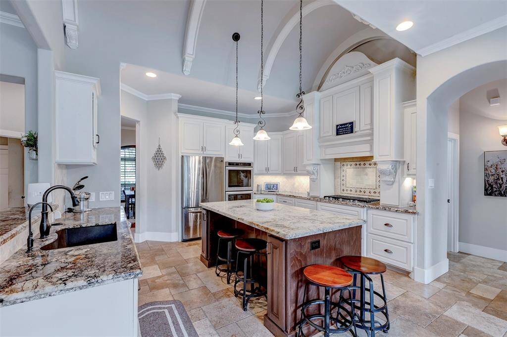 Kitchen features vaulted ceiling, large island with granite countertop.