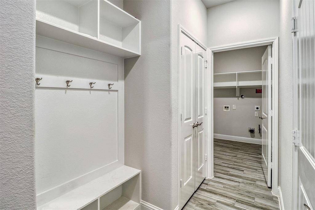 This area leading to the utility room and garage has a built-in mud bench and coat closet.