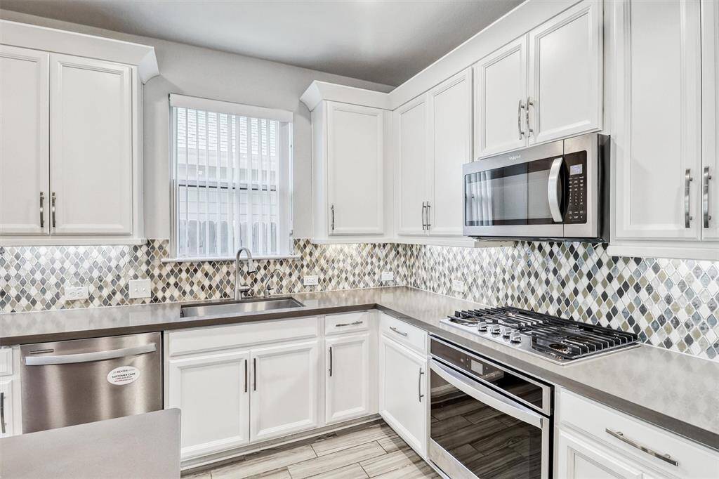 The Kitchen has ample cabinetry and features a gorgeous backsplash and stainless steel appliances.