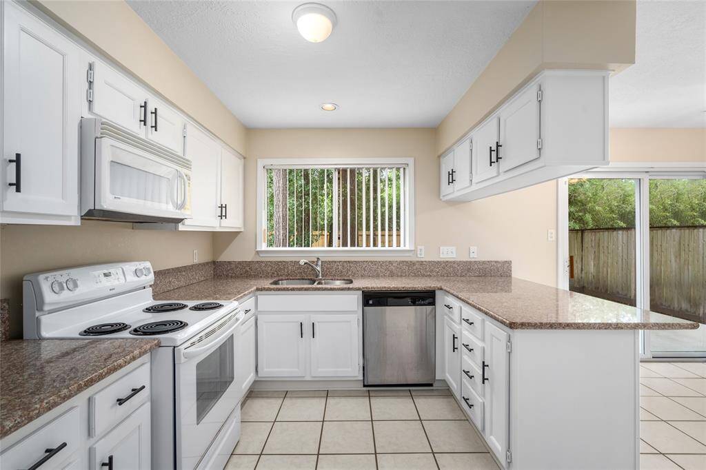 The kitchen has granite countertops, newly painted wood cabinets with new hardware.