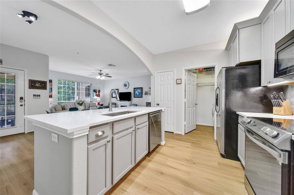 View of the kitchen, living, and dining from the hallway leading to the bedrooms. Great space to have friends over.