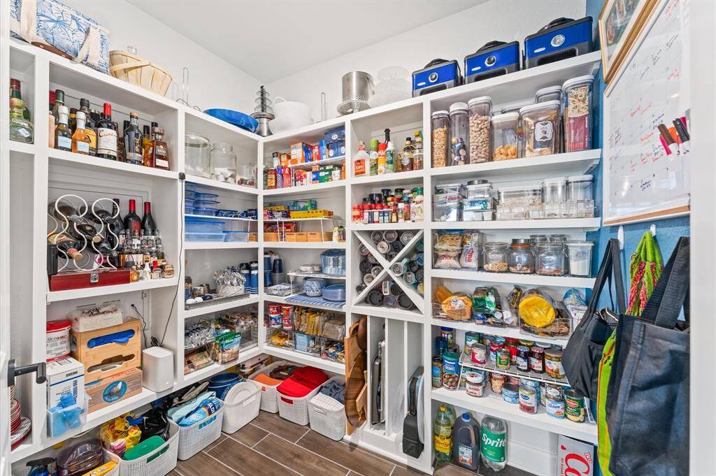 Incredible walk-in pantry with floor-to-ceiling custom shelving, wine and spice storage, and room for every kitchen essential.