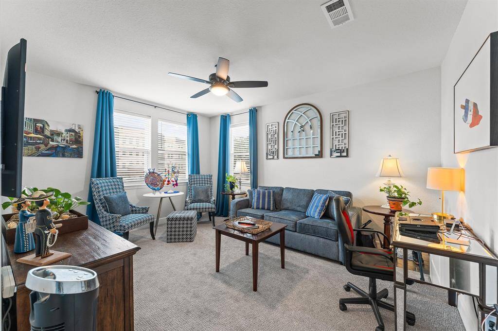 Perfect for working from home or unwinding, this flexible room offers seating, workspace, and great natural light from corner windows.