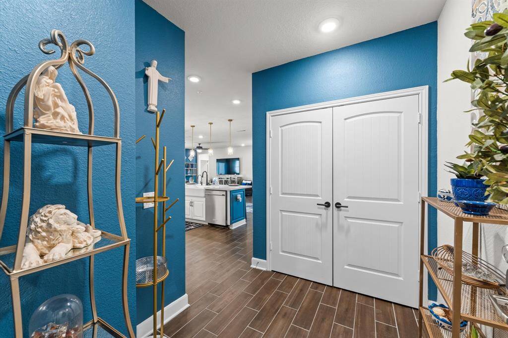 Bright, stylish entry featuring bold accent walls, upgraded fixtures, and direct views into the open-concept living space.