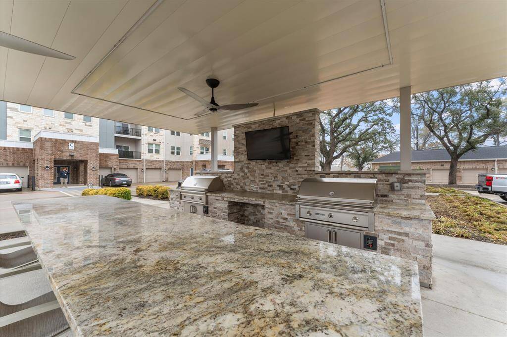 Resort-style outdoor kitchen and grilling station with covered seating, perfect for hosting barbecues and gatherings.