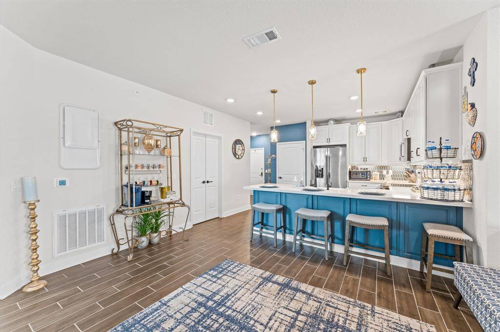 Expansive island with bar seating for four—perfect for hosting or everyday dining—framed by gold-tone lighting and striking color contrast.