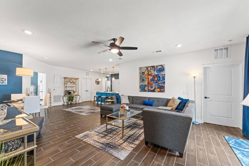 Modern layout featuring a large sectional, statement art, ceiling fan, and stylish finishes for everyday comfort and entertaining.