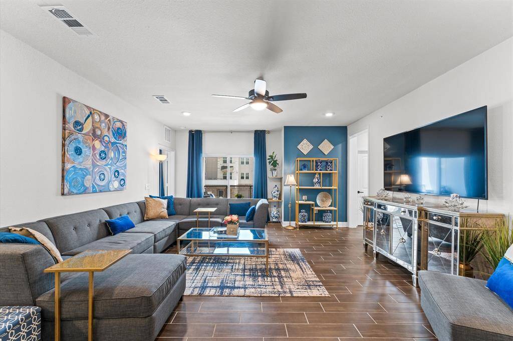 Elegant yet cozy, this living space is anchored by a custom media console, designer shelving, and bold accent wall.