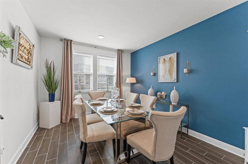 Host memorable dinners in this spacious formal dining room with a striking accent wall, upscale furnishings, and a modern chandelier.
