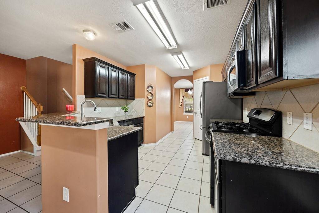Another view of the kitchen with a breakfast bar and recessed lighting.