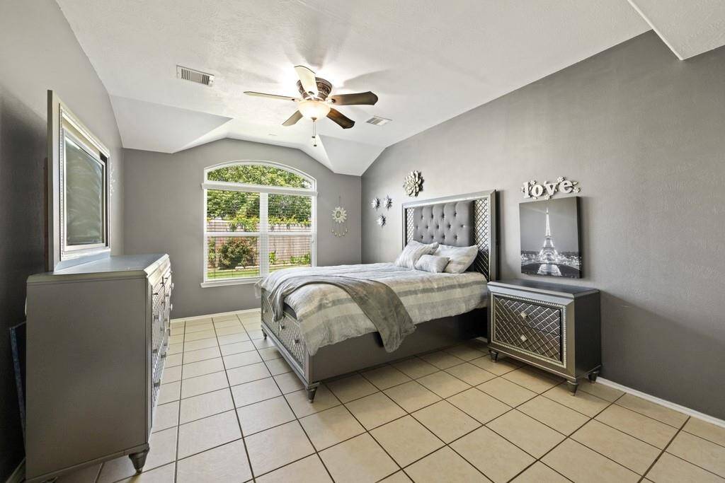 Primary bedroom with beautiful natural light overlooking the lush backyard.