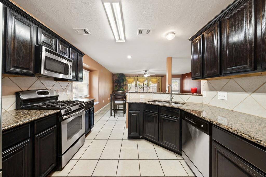 Modern kitchen with granite countertops, stainless steel appliances, and ample cabinetry.