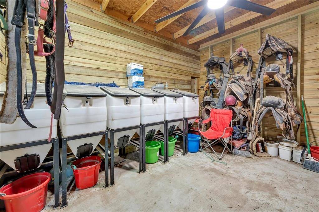 Tack room and feed concrete slab run with electricity and industrial ceiling fans.