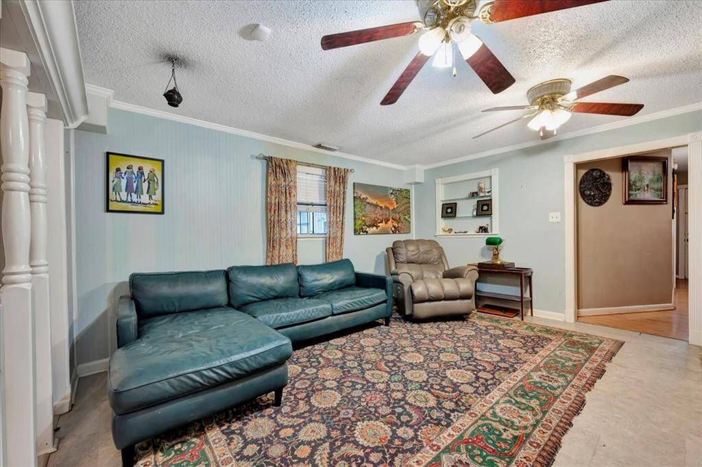 Inviting living area with decorative wainscotting on the ceiling and hand carved wooden spindles.