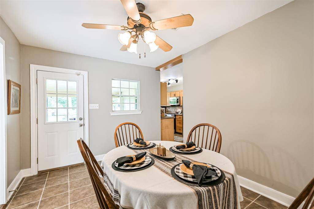 With a ceiling fan for comfort and direct access to the charming covered back porch, this breakfast area blends function with inviting style.