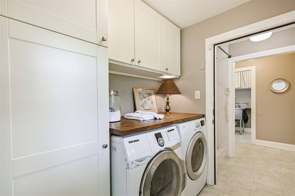 This laundry room might just steal your heart! With beautiful cabinetry, side-by-side washer and dryer, and a built-in folding counter, it’s a perfectly functional space that feels almost too charming for doing laundry.