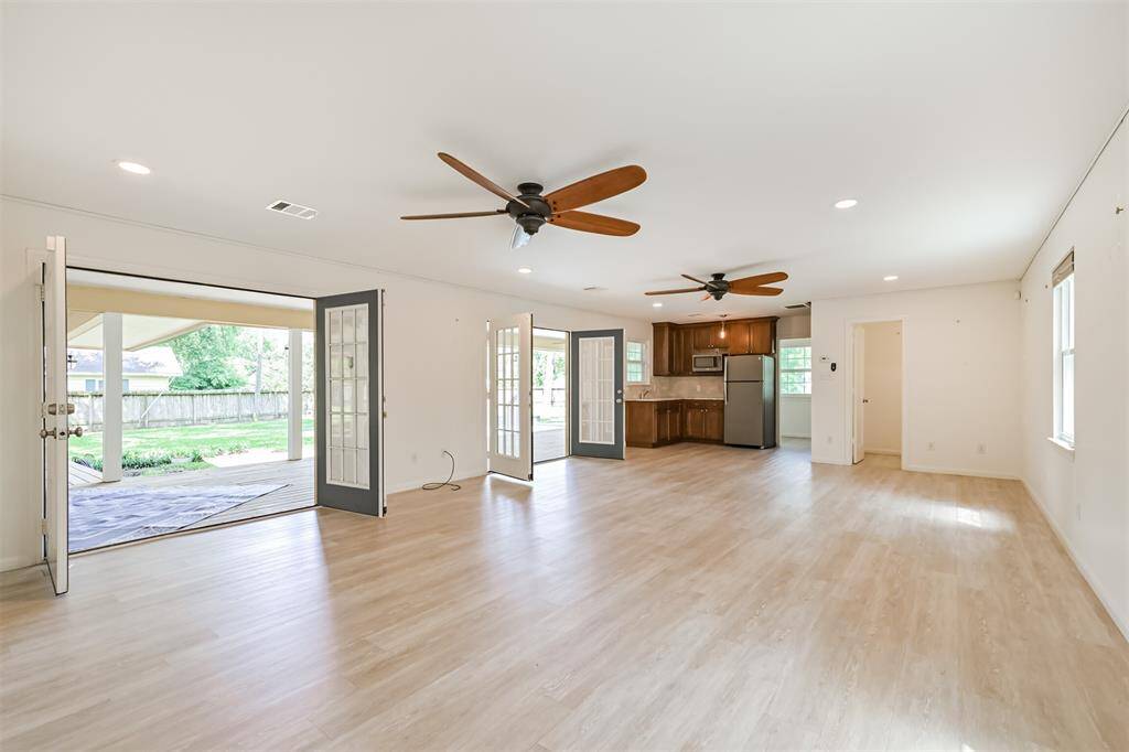 Your first glimpse of the beautiful 2016 addition, which elevates the entire home. Two sets of French doors open to the back porch, allowing you to bring the outdoors in or keep them closed for privacy. With its own AC unit, gorgeous flooring, and natural light, this space is as comfortable as it is stylish.