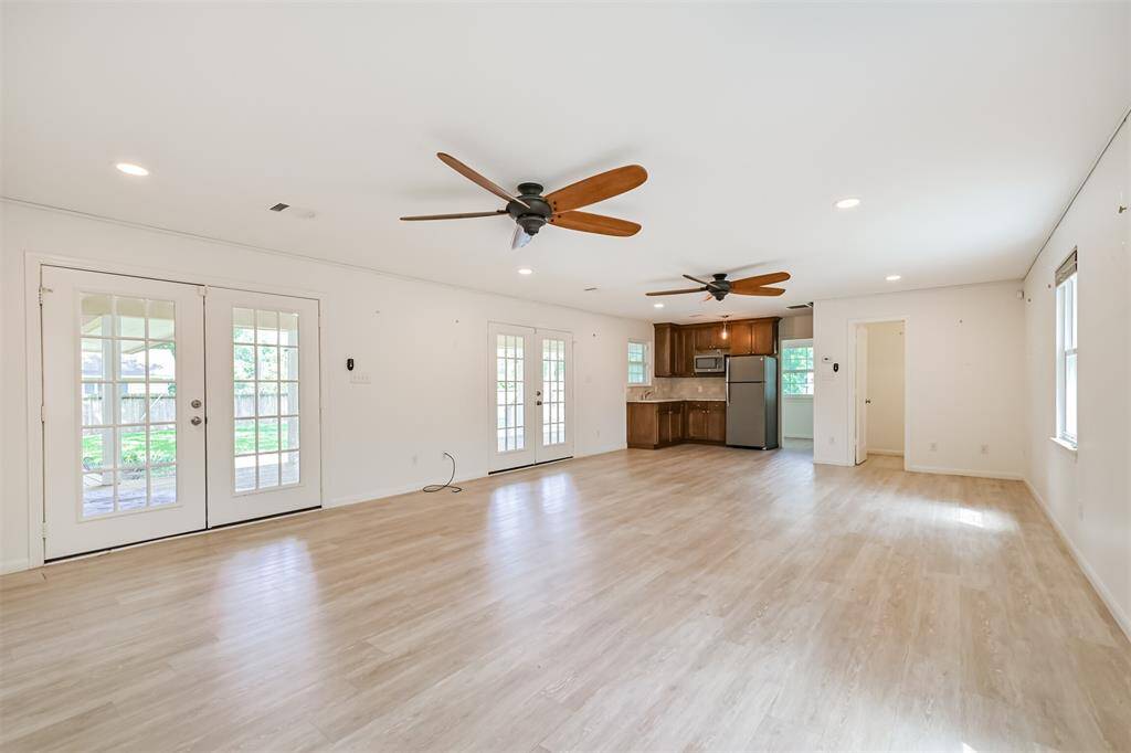 This spacious addition offers a seamless blend of form and function, complete with a primary suite upstairs, a kitchenette, a half bath downstairs, and a flexible space in the back. The two sets of French doors provide easy access to the back porch, perfect for enjoying the outdoors in style.  Take note of the multiple ceiling fans and well-designed recessed lighting!