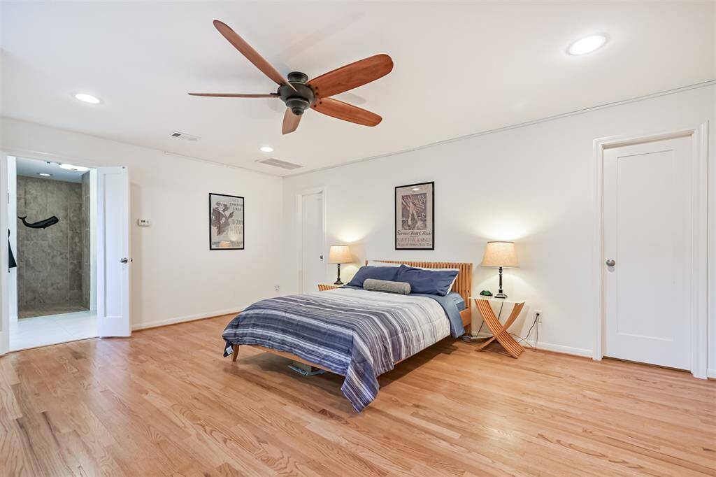 This incredible primary suite, located in the upstairs portion of the 2016 addition, is truly a dream. The oversized room offers plenty of space for a cozy seating area or home office setup, and features beautiful wood flooring that extends into both walk-in closets. A large window offers peaceful views of the backyard and pool below.