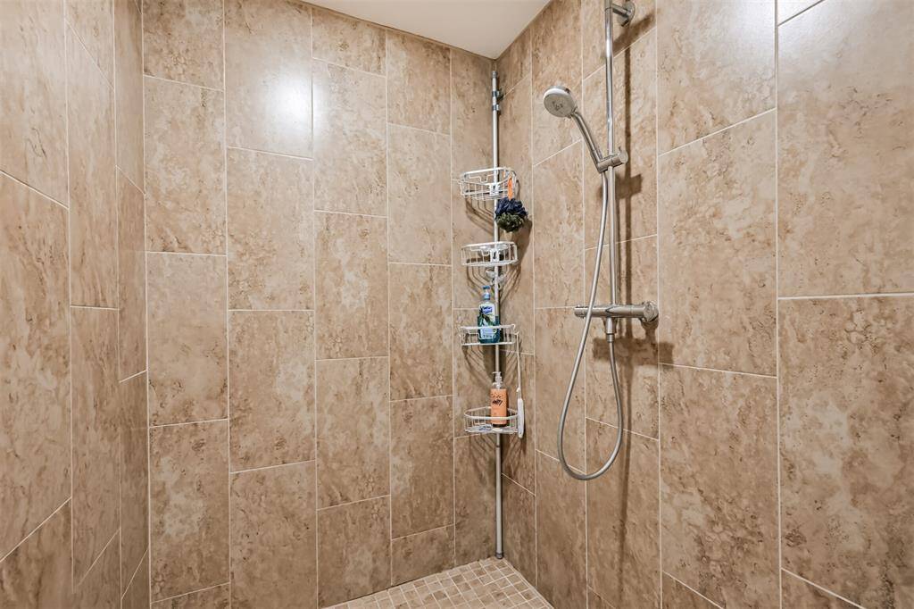 Step into the luxurious, door-free walk-in shower—so spacious it needs no enclosure. Multiple shower heads and floor-to-ceiling tile create a spa-like experience right at home.