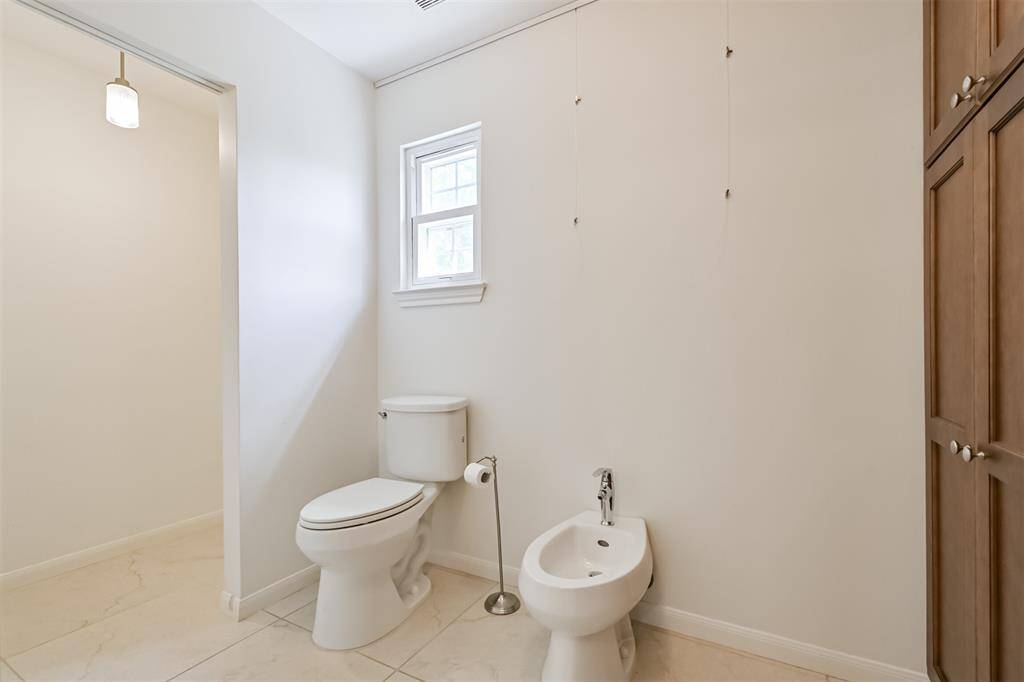 Tucked within the spacious en suite is a private water closet—complete with a separate bidet for added comfort. Just beyond, discover a second laundry room, making everyday living even more convenient and luxurious.