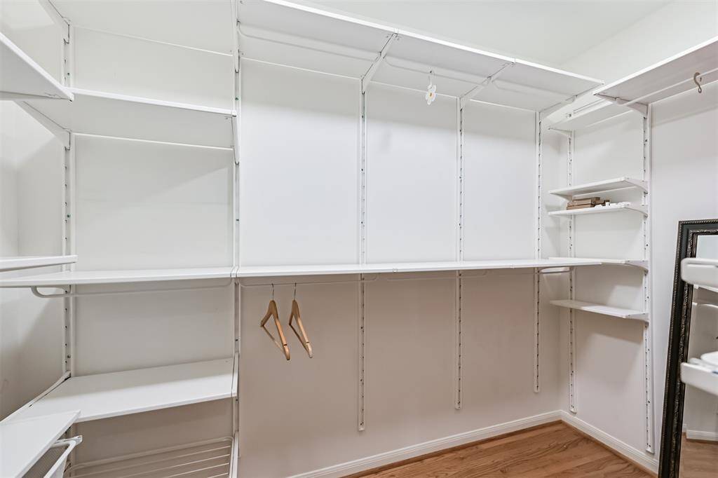 One of two meticulously designed walk-in closets in the primary suite—offering generous space, thoughtful layout, and beautiful wood floors to keep everything organized in style.