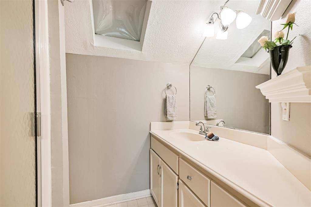 This private bathroom features a glass-framed walk-in shower, offering a functional and comfortable space just off the oversized bedroom suite.