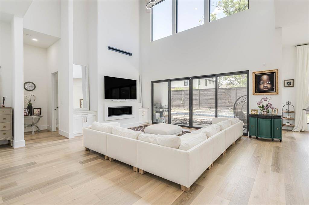 Expansive windows fill the living room with abundant natural light, highlighting the open layout and enhancing the airy ambiance