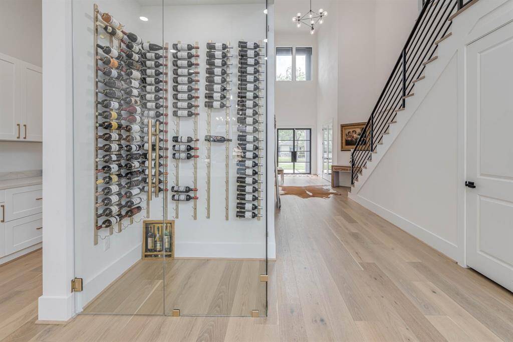 This stunning wine room features floor-to-ceiling glass doors that create a dramatic showcase for your collection while maintaining a sleek, contemporary aesthetic.