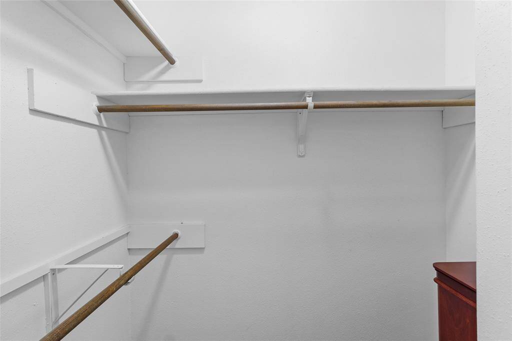 Here is your second spacious walk-in closet, featuring multiple hanging rods perfect for keeping your belongings organized and easily accessible.