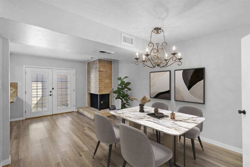 Your dining area offers a warm and inviting space for meals and gatherings. A cozy brick fireplace adds charm, while French doors bring in abundant natural light, creating an open and welcoming atmosphere.