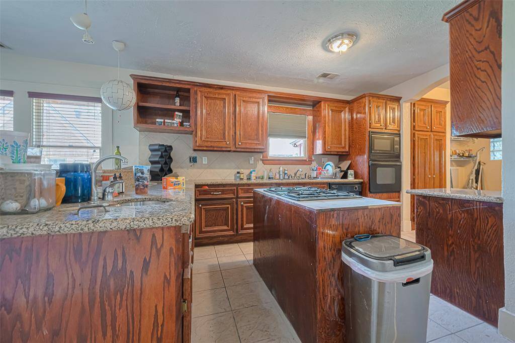 Updated kitchen with granite countertops and island with gas cooktop
